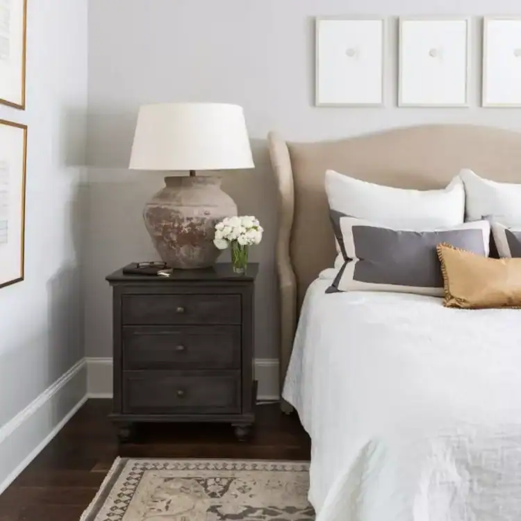Neutral bedroom with light grey wallsm a cream padded headboard and cream lamp. Calm Bedroom Ideas