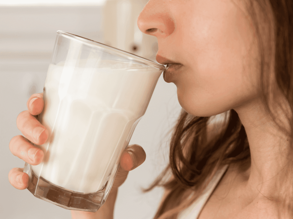 Upclose sideview shot of a woman drinking a large glass of water