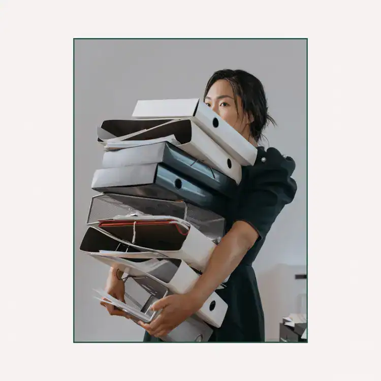 A-Woman-Holding-a-Pile-of-File-Folders
