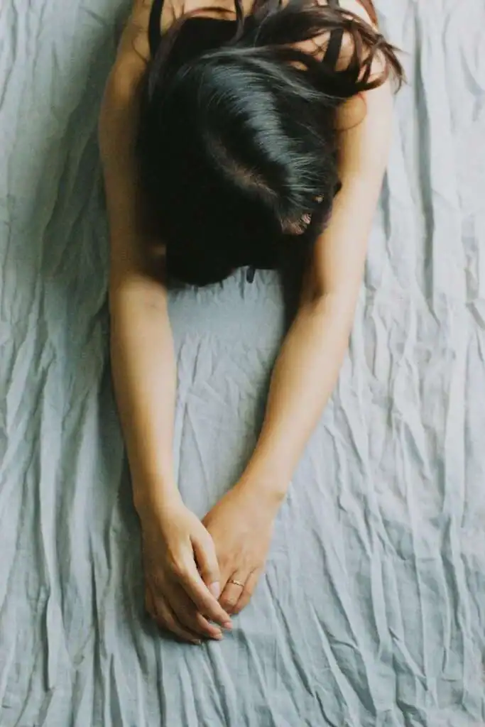 Woman-stretching-her-arms-out-on-her-bed.-Saturday-self-care-routine