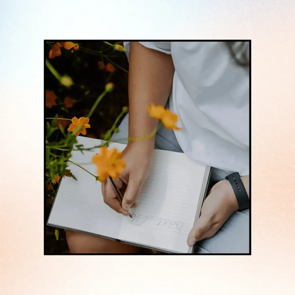Woman-writing-in-a-notebook-outdoors-around-nature.-Scripting-Manifestation-Technique