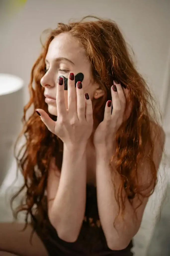 beautiful ginger-haired woman applying eye masks