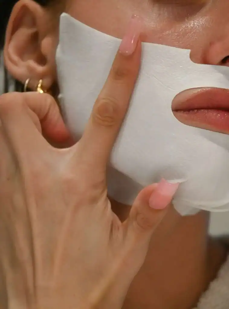 woman-applying-a-sheet-mask-to-her-face.-Saturday-self-care-routine