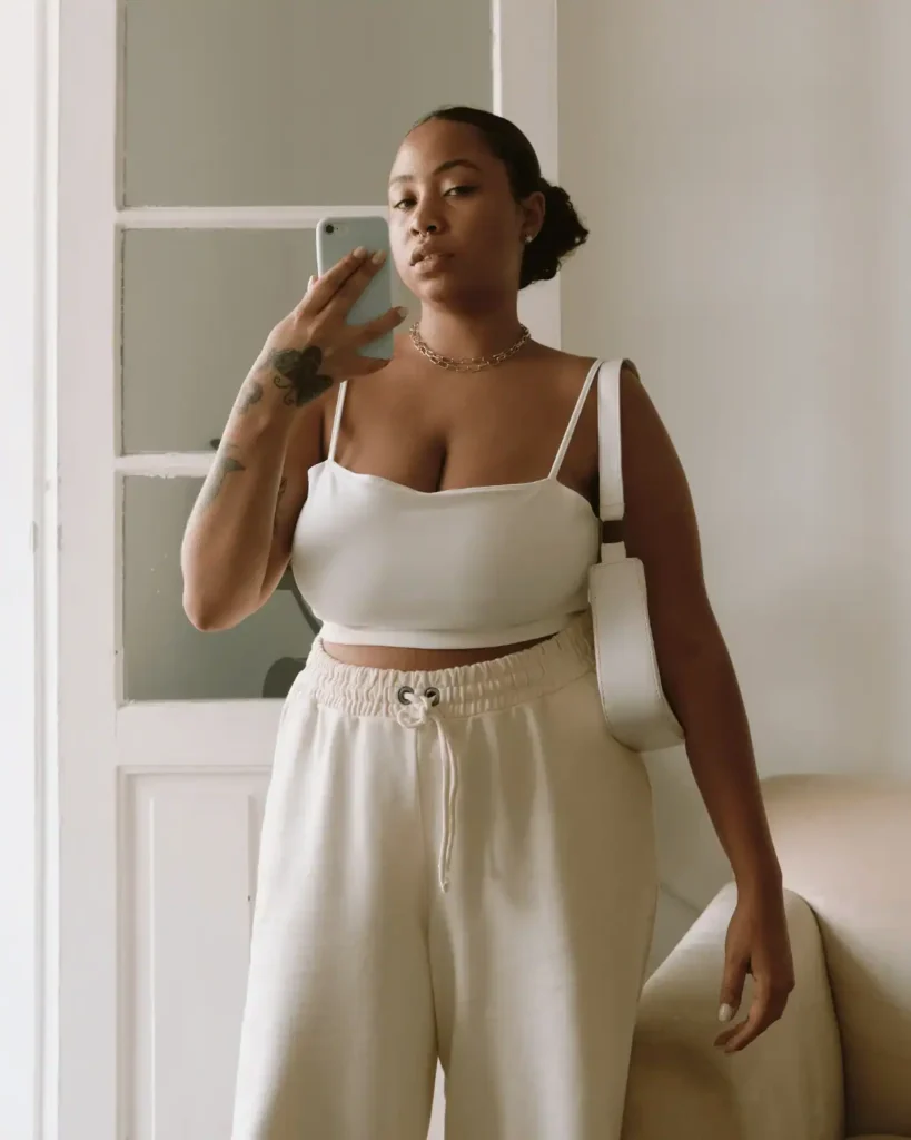 woman-with-a-neutral-white-and-cream-outfit-and-a-bag-taking-a-selfie-indoors.-Pillow-method