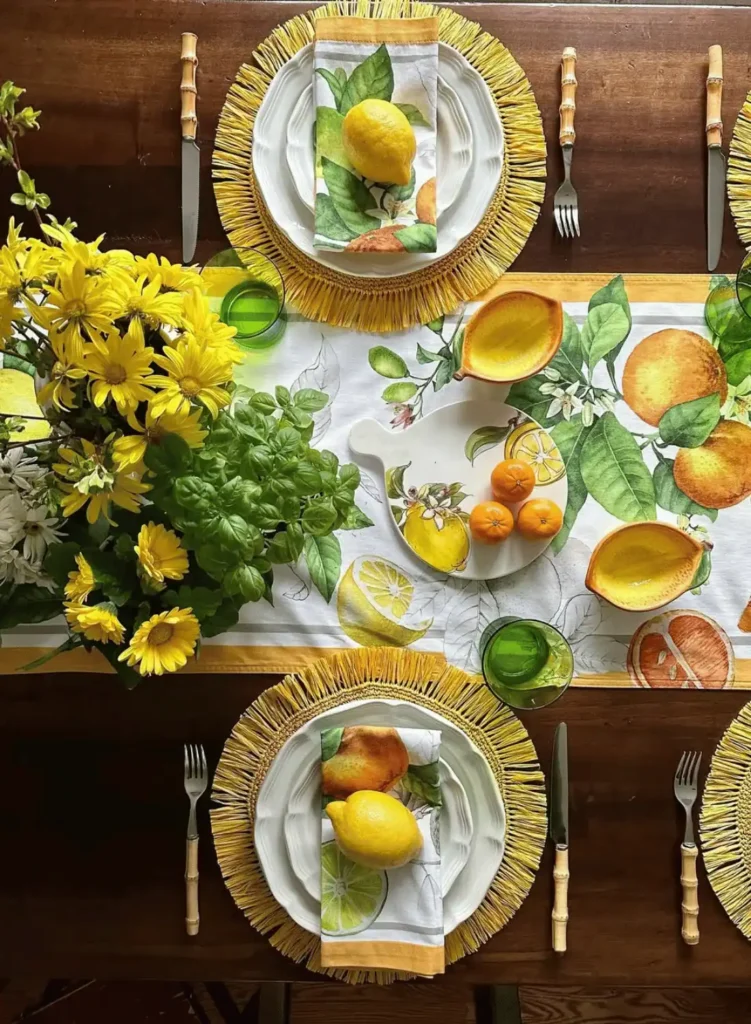A table set with yellow and orange plates and place settings.