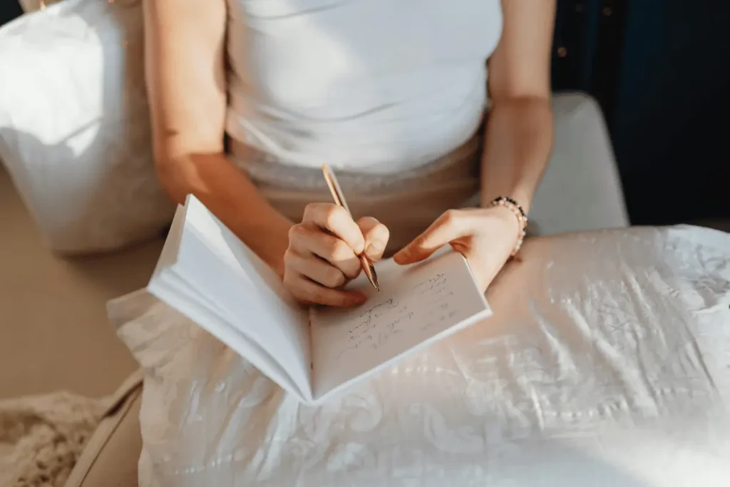 woman writing in a notebook with a gold pen. 6-step miracle morning routine
