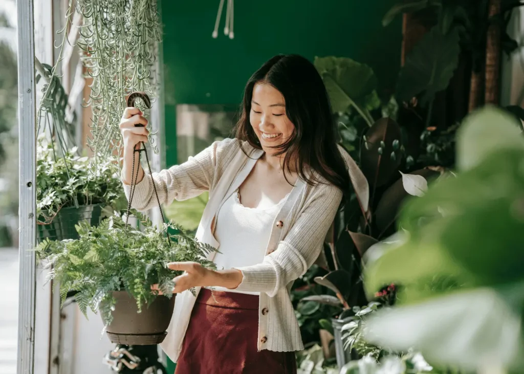 Asian woman tending to plants at home. Hobbies For Introverts