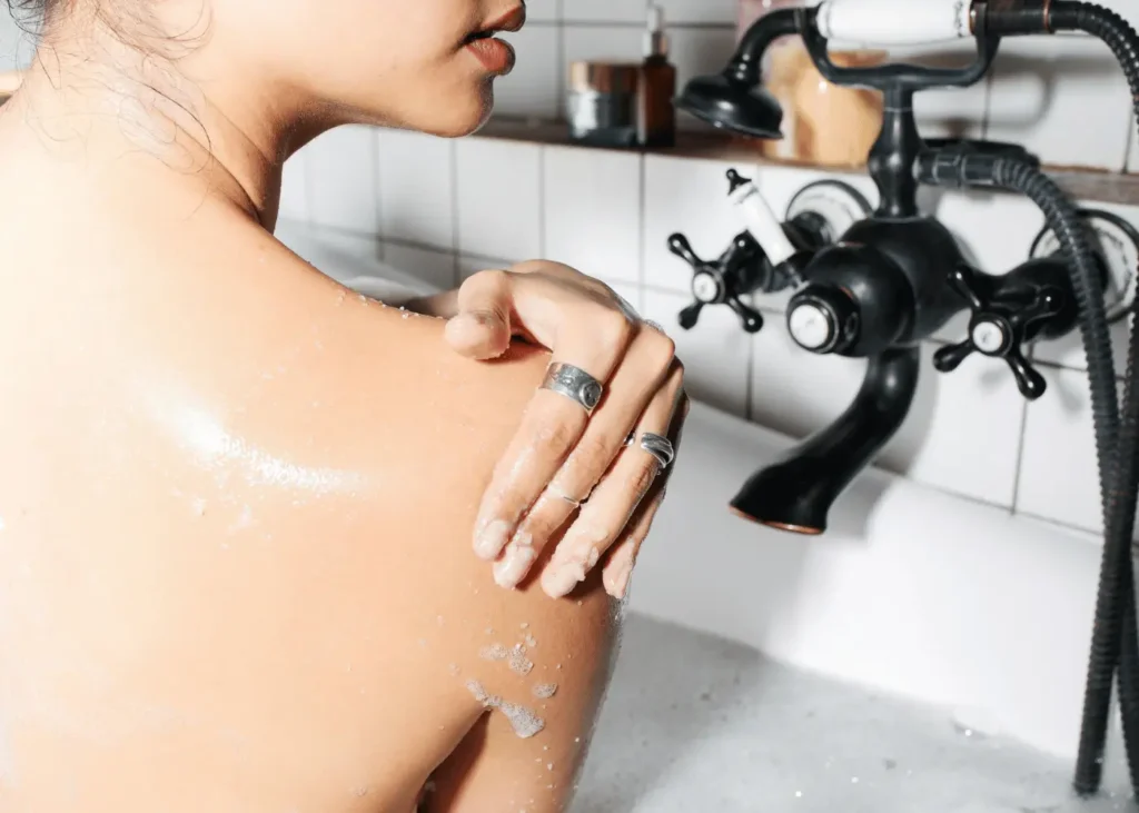 Hand on Shoulder of Woman in Bathtub. Rainy day activities