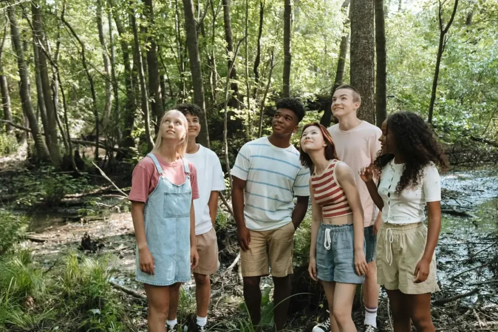 Group of Teenagers in a Forest Looking Up. Summer Bucket List Ideas For Teens