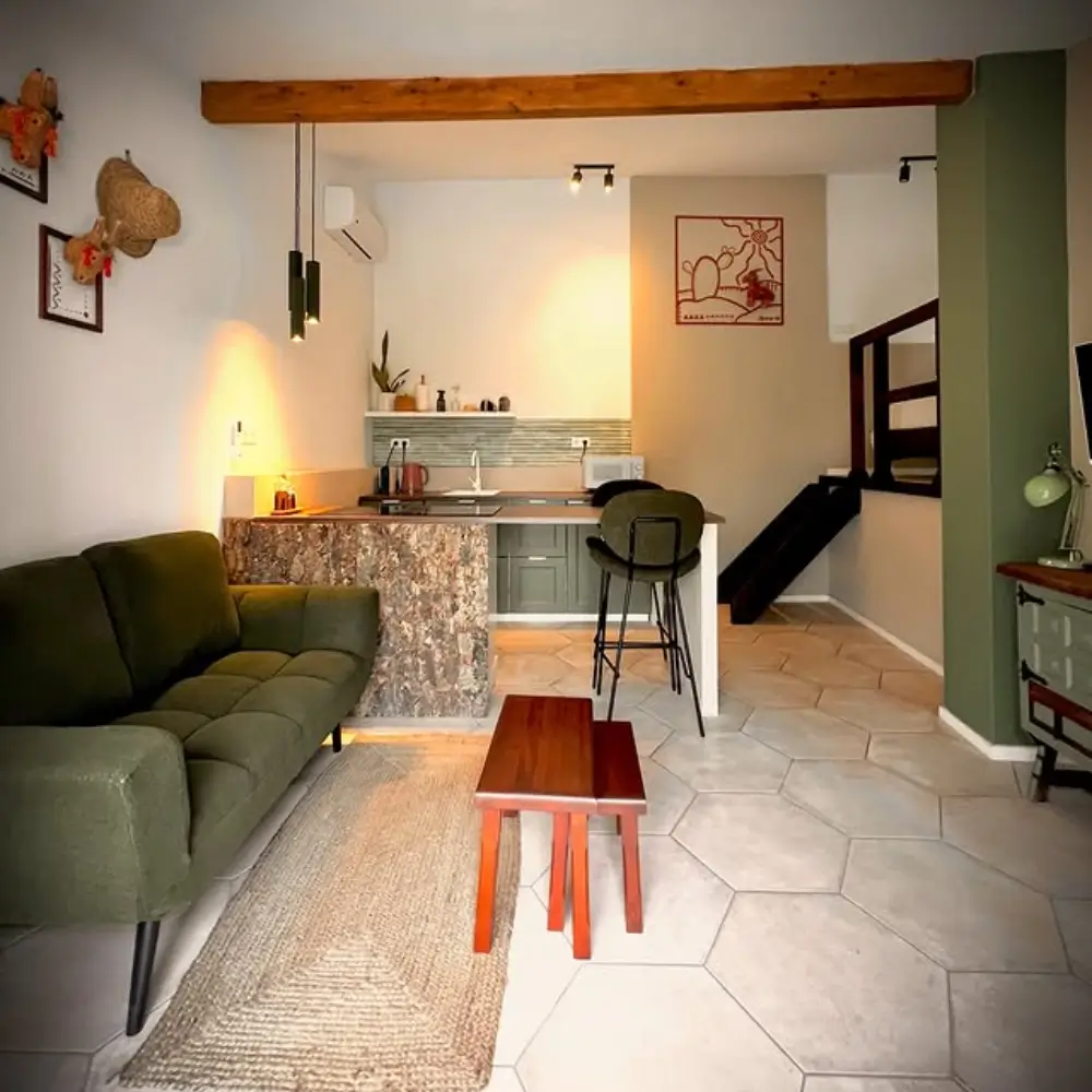 A MODERN LIVING ROOM WITH POPS OF MOODY GREEN ACCENTS