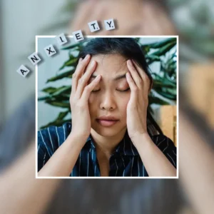 A woman sitting indoors, holding her head in stress or worry, surrounded by plants. Journal Prompts for Anxiety