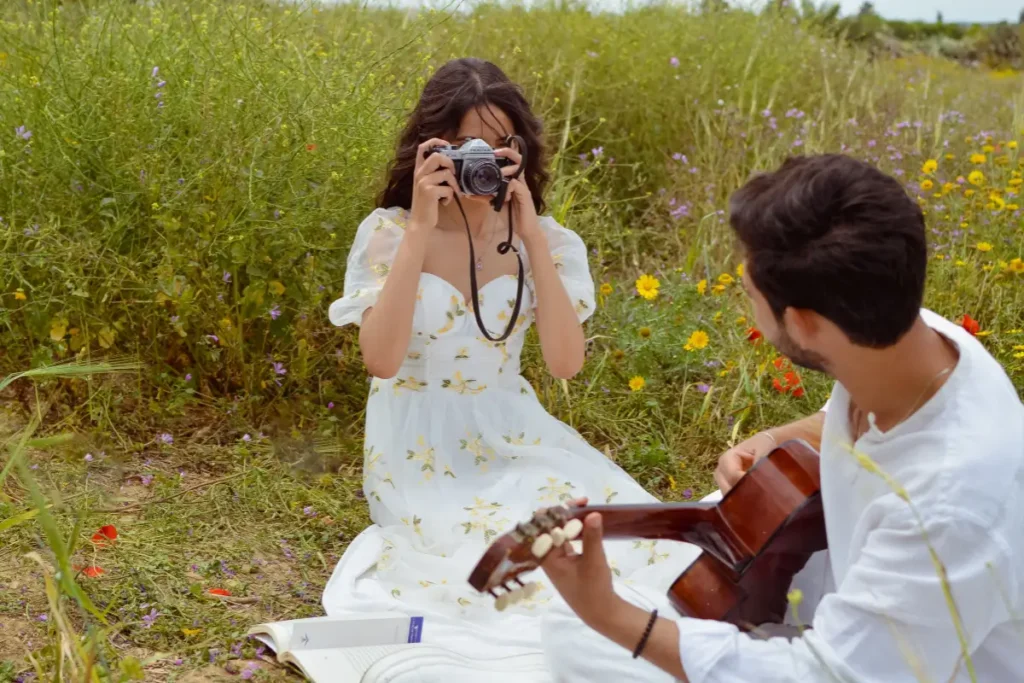 Romantic scene of a young couple in a vibrant flower field, capturing memories. Couples Bucket List Ideas