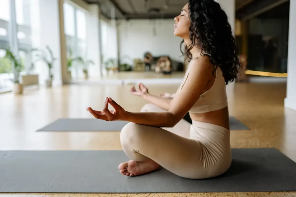 Serene woman practicing yoga meditation in a bright modern studio setting. Best Yoga Captions for Instagram