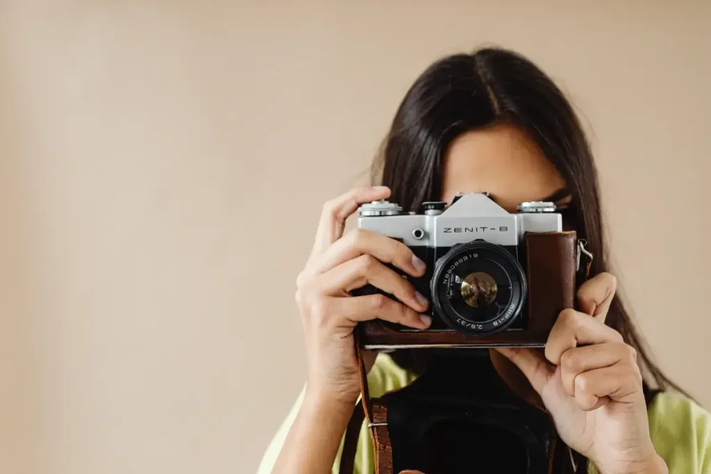 Close-up of a woman holding a vintage camera, capturing the essence of photography art. Hobbies for Women Over 40