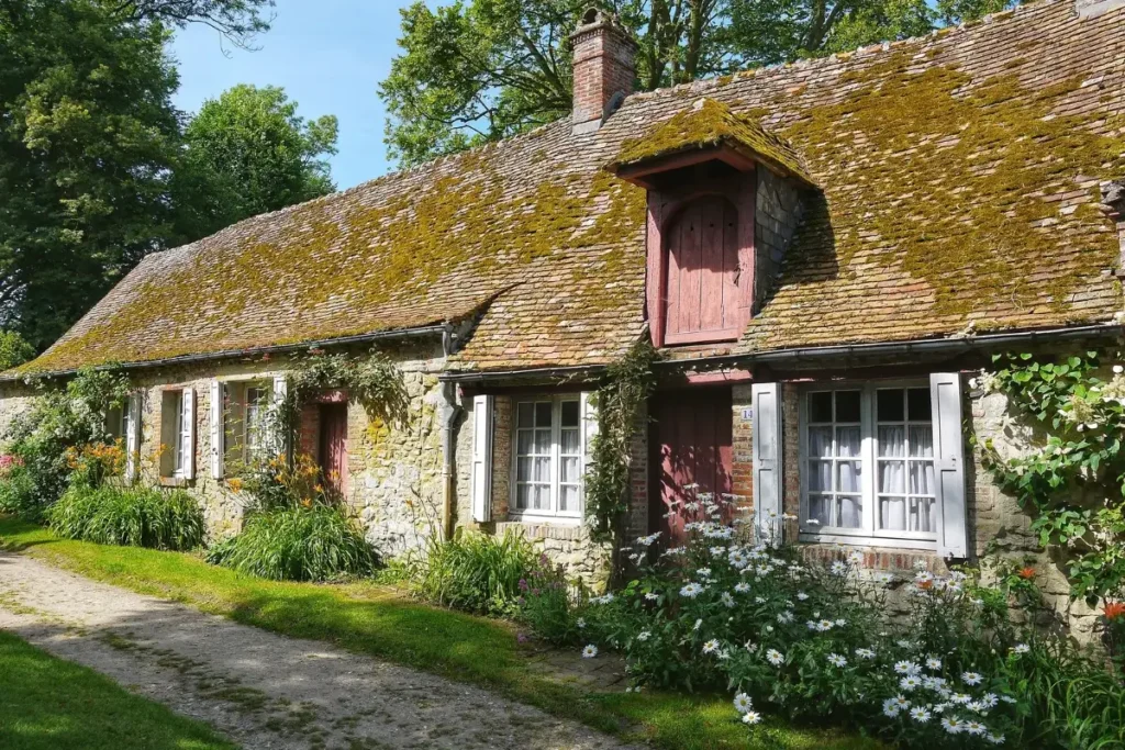 Idyllic stone cottage with mossy roof and vibrant garden in a peaceful setting. Funny House Names