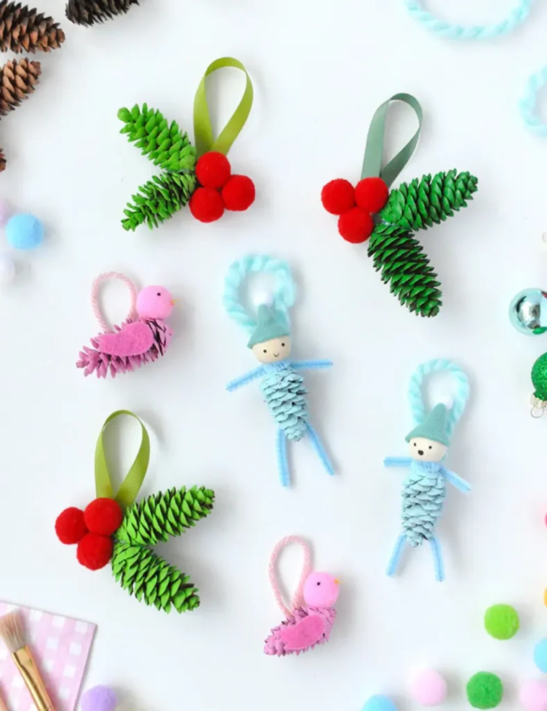 Mini pinecones painted pink, green and blue, made into birds, holly sprigs and a small elf with a felt hat.