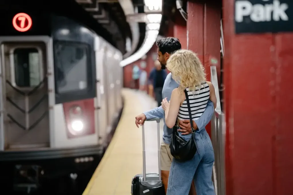 A couple embraces while waiting for a subway train at an urban station platform. Date Night Ideas