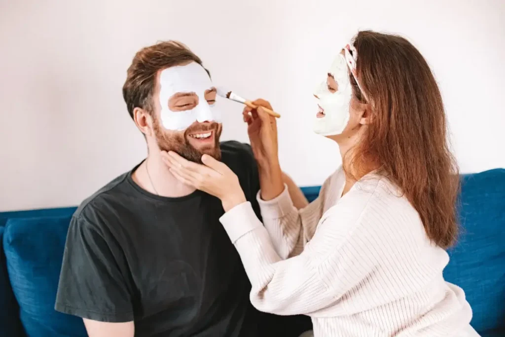 A happy couple applying facial masks together, highlighting joy and skincare in a cozy home setting. Date Night Ideas