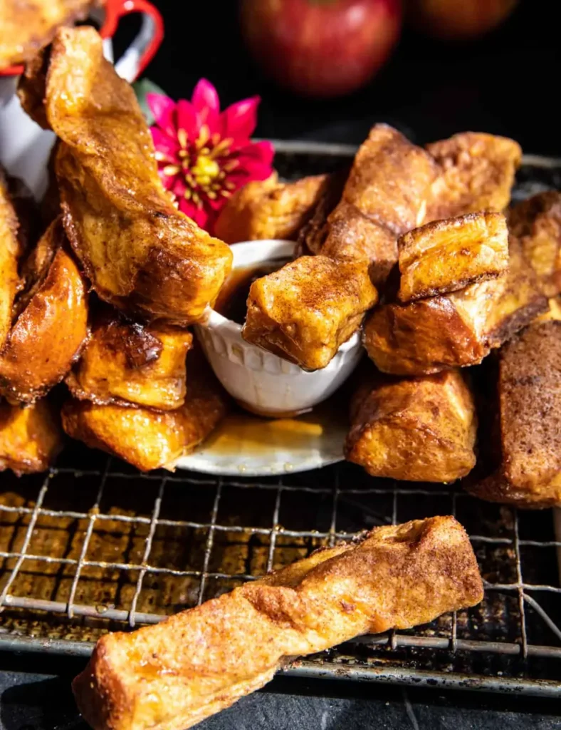 Apple butter cinnamon French toast sticks stacked on a plate with syrup