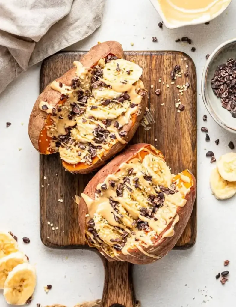 Baked sweet potato halves stuffed with breakfast toppings on a sheet pan