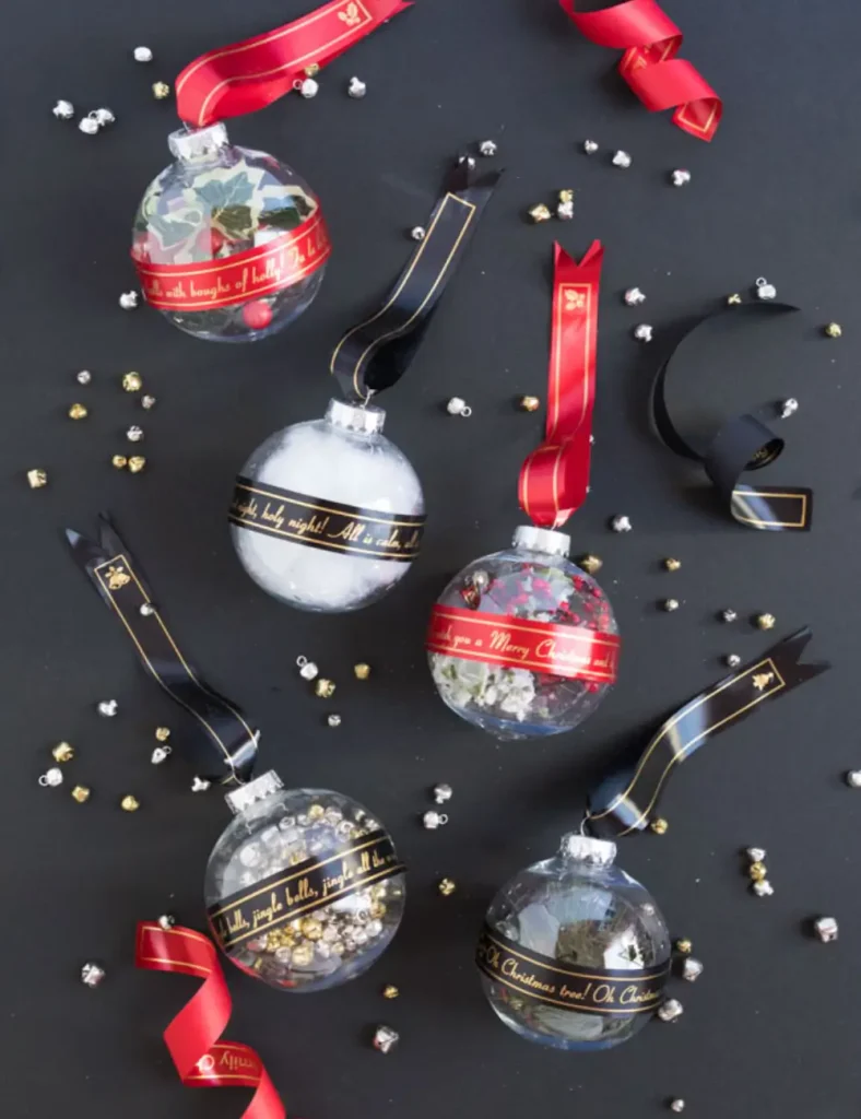 Clear ornament filled with mini jingle bells, wrapped with a printed white satin ribbon and matching hanger.