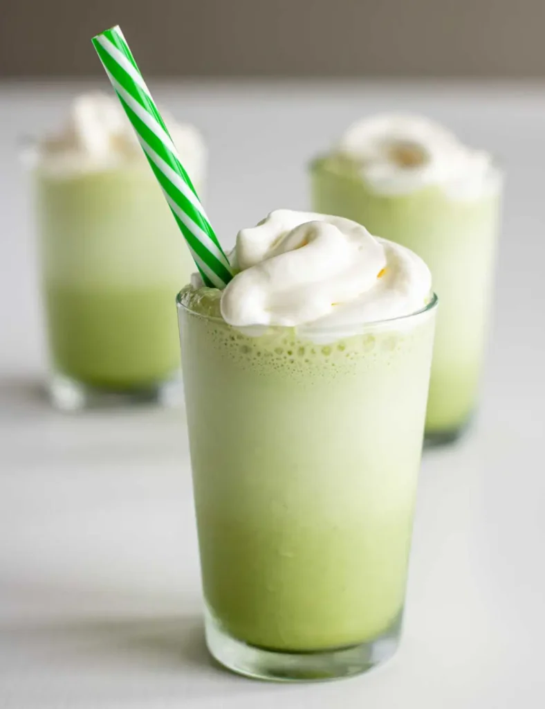 Copycat Starbucks matcha frappuccino topped with whipped cream and a green straw
