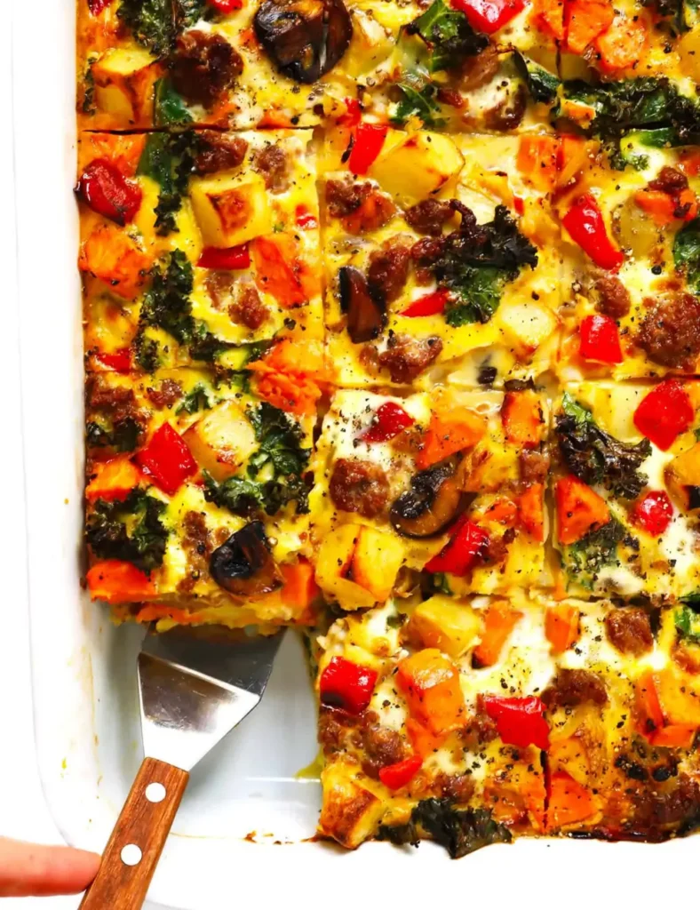 Cozy autumn breakfast casserole in a baking dish, scooped to show layers