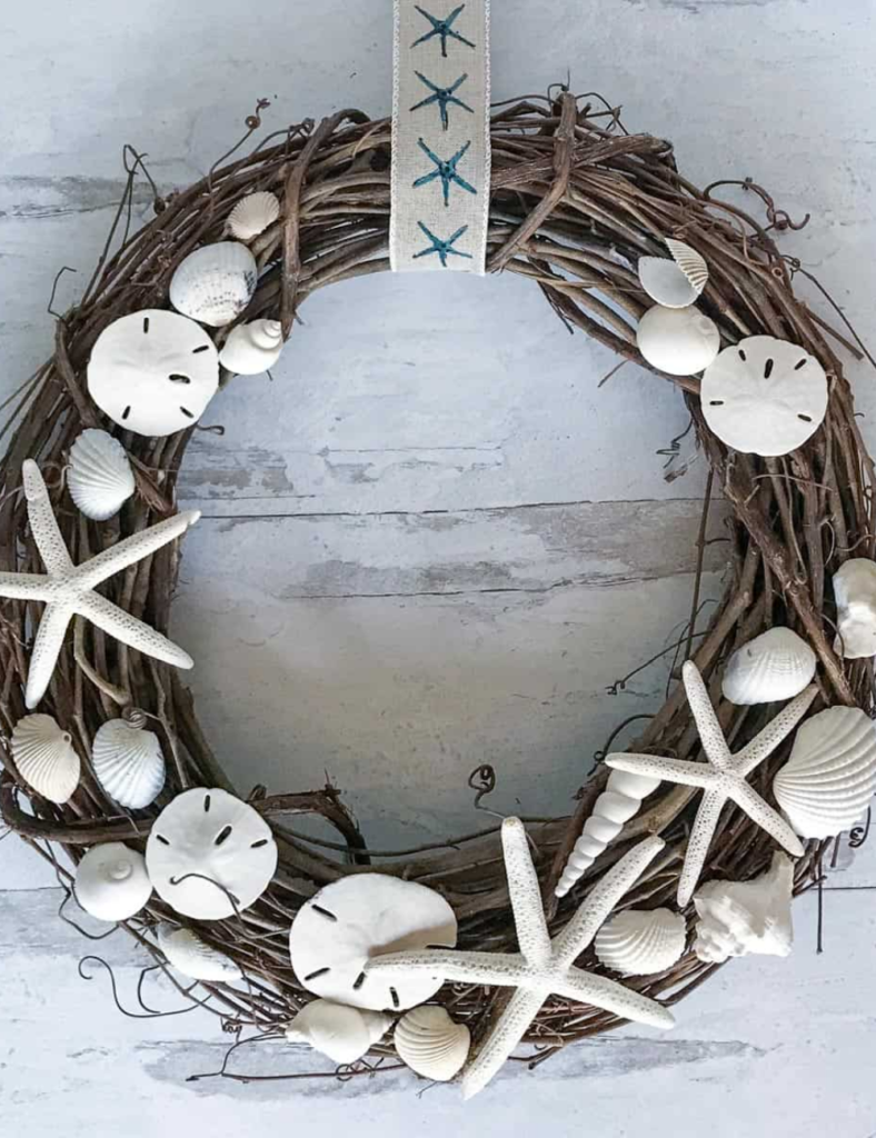 Grapevine seashell wreath with a large white finger starfish and assorted shells tied with ribbon