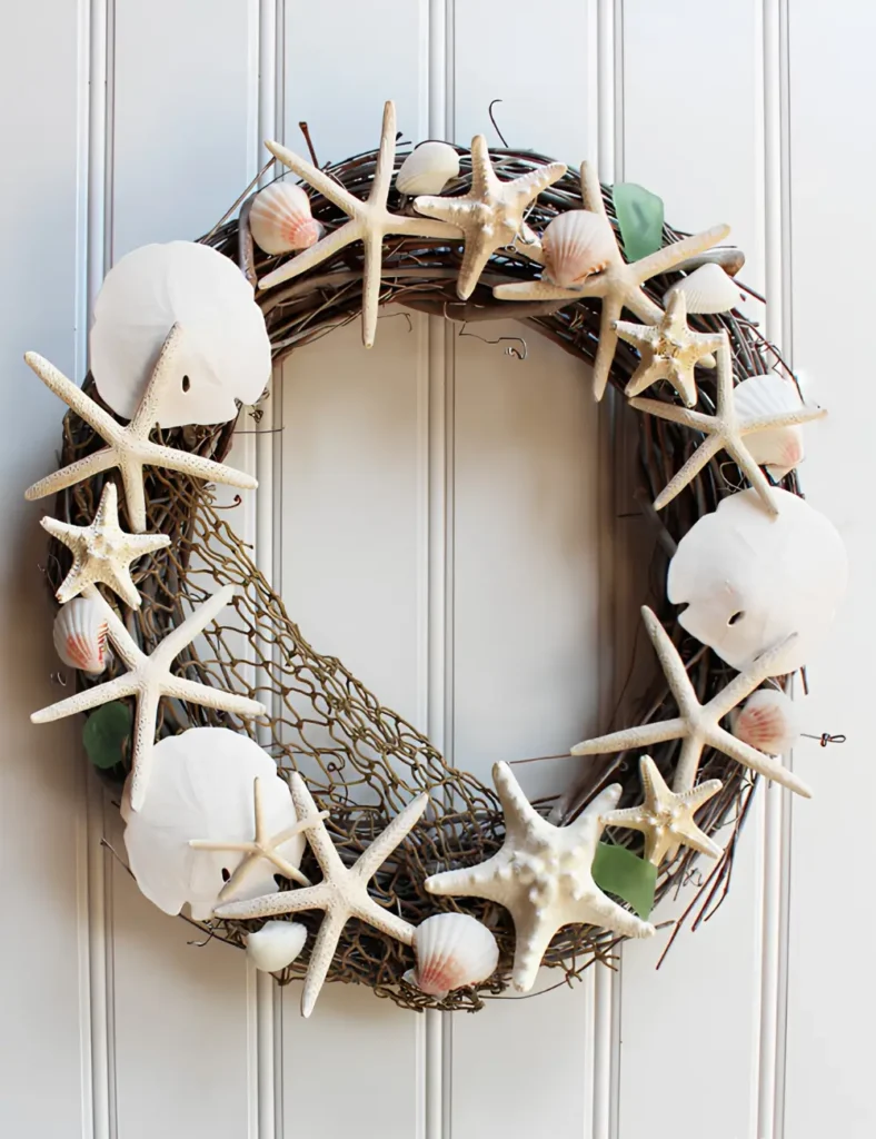 Grapevine shell wreath with sand dollars, pencil starfish and sea glass layered over a fish net base
