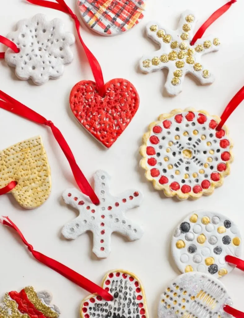 Painted salt dough ornaments in white, red, gold and silver, laid flat on a white background.
