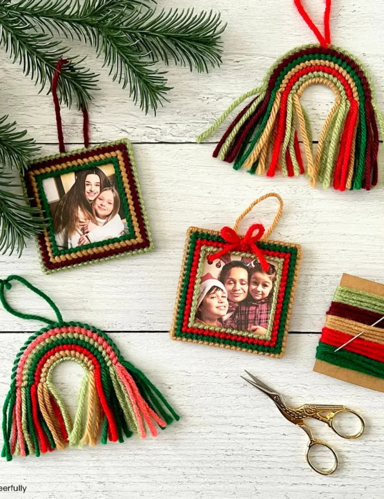 Plastic canvas ornament frame stitched in red, green and tan yarn with a photo in the center and a small yarn bow.