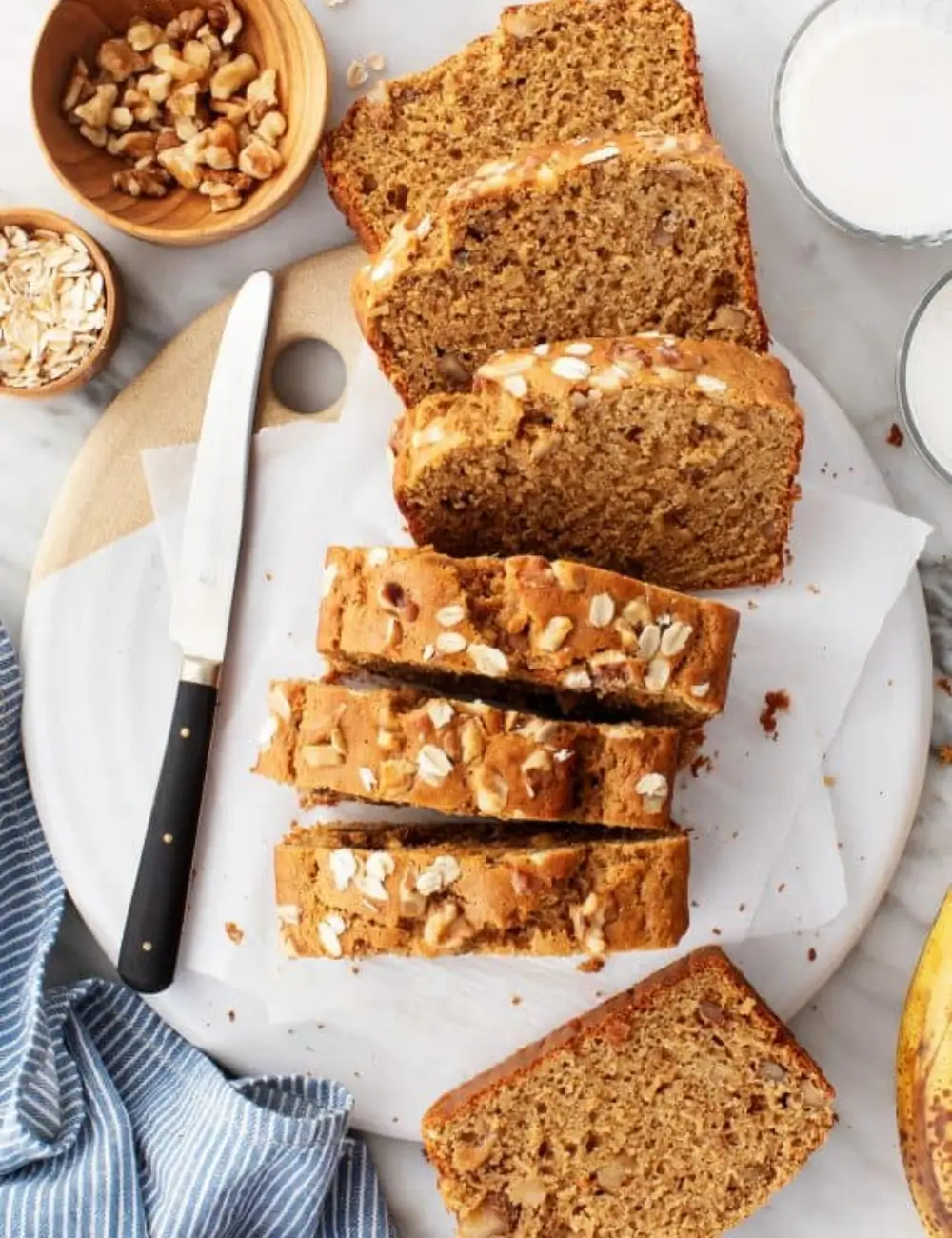 Sliced gluten-free banana bread loaf on a wooden board