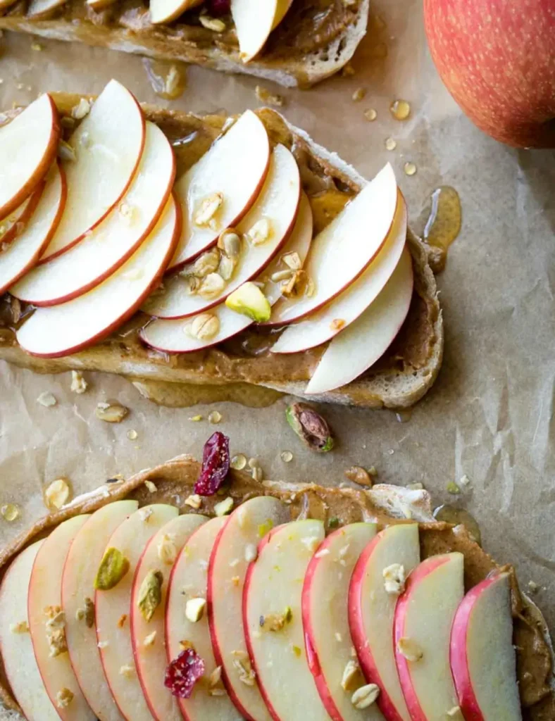 Slices of toast topped with peanut butter, thin apple slices and cinnamon