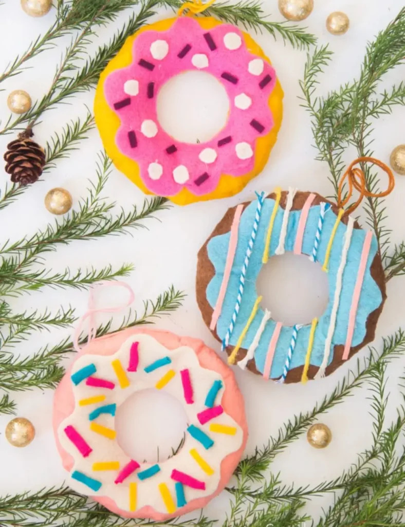 Stuffed felt donut ornaments in pastel colors with wavy glaze tops and yarn sprinkles.