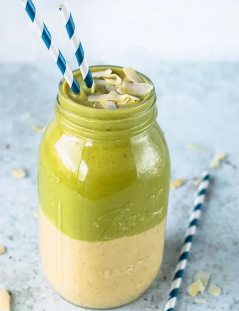 Two-layer peanut butter and matcha smoothie topped with toasted coconut flakes