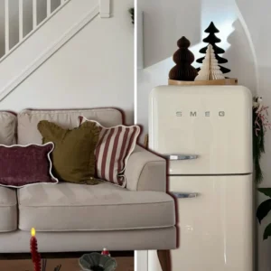 Small apartment Christmas decor with festive cushions on a cream sofa and paper trees on top of a retro fridge.