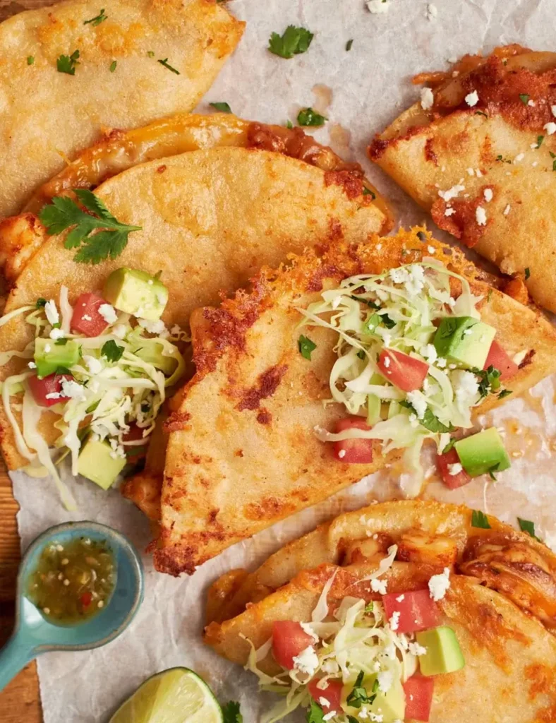 Crispy folded shrimp tacos topped with tomatillo salsa and crumbled cotija