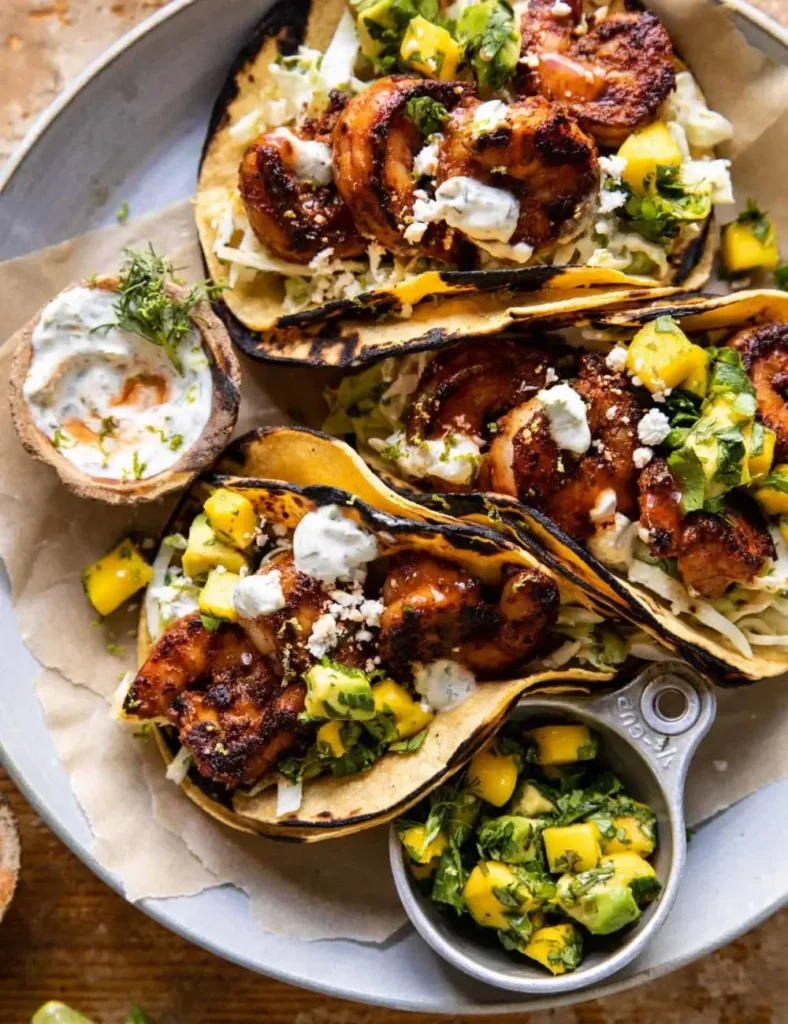 Chipotle BBQ shrimp tacos topped with ranch slaw and mango avocado salsa