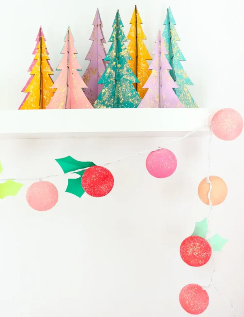 Glittery colorful holly-inspired string light garland draped over a shelf