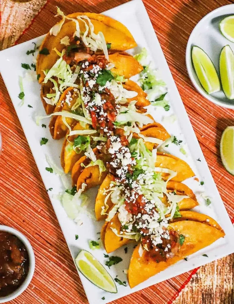 Crispy fried shrimp tacos dorados topped with lettuce and crumbled cheese