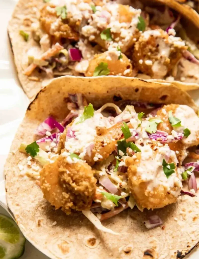 Baja shrimp tacos topped with cabbage slaw, cotija cheese and cilantro