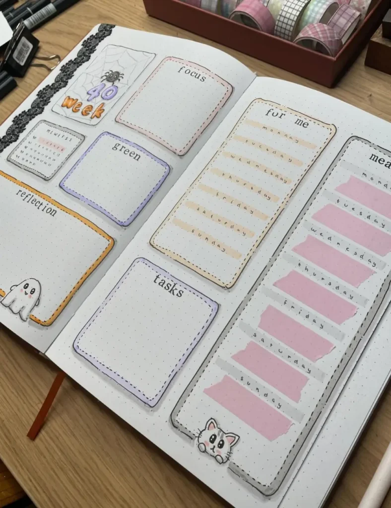 Halloween bullet journal weekly spread with stitched-outline boxes, a lace border and cute ghost and cat doodles