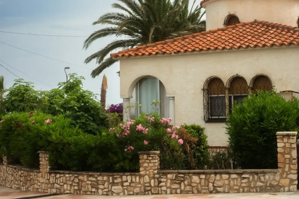 A beautiful Mediterranean-style villa with a garden of vibrant greenery and flowers