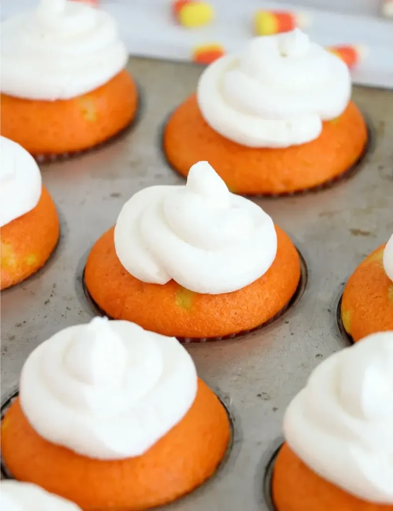 Candy corn cupcakes with yellow and orange cake layers and white frosting