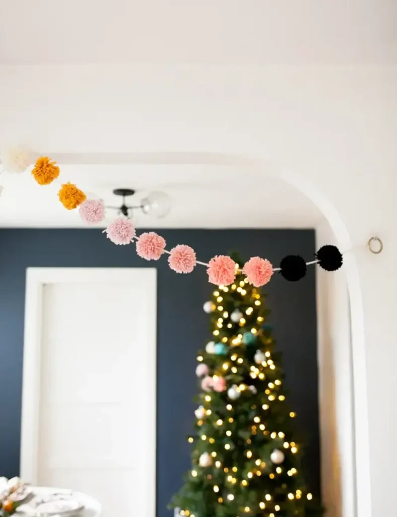 Colorful yarn pom pom garland hanging in a doorway