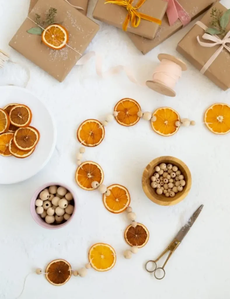 Dried orange slice garland with wood beads draped near wrapped presents