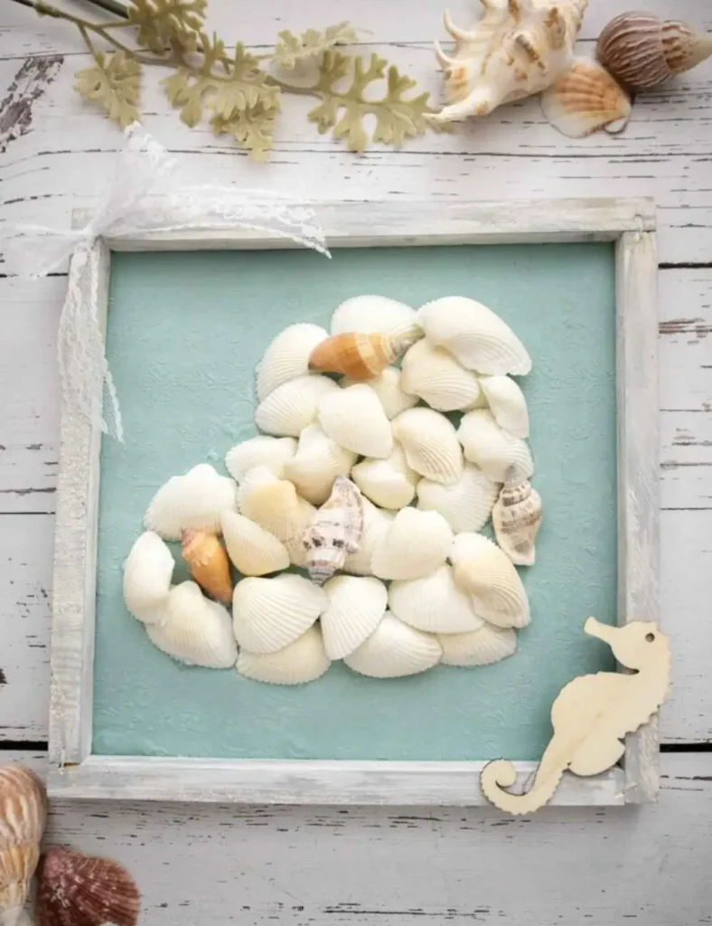 Framed canvas wall art with a heart shape made from layered seashells