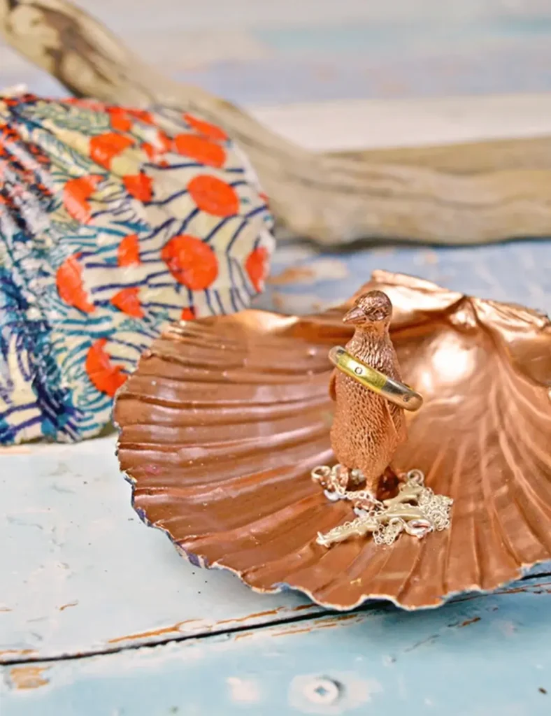Gold scallop shell ring dish with a small sea creature figurine glued in the center