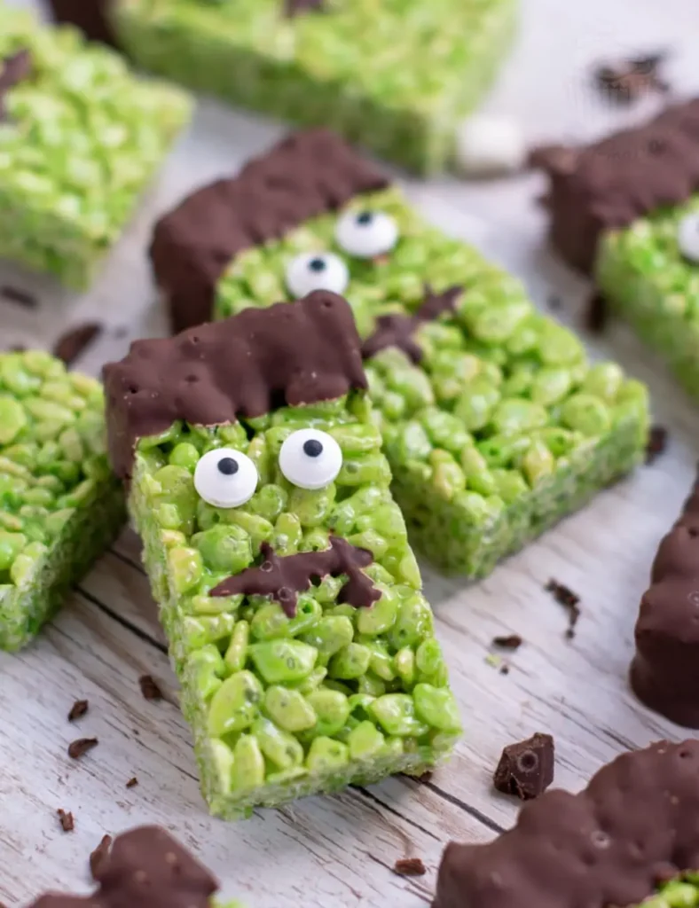 Green Frankenstein-themed Rice Krispie squares dipped in chocolate with candy eyes