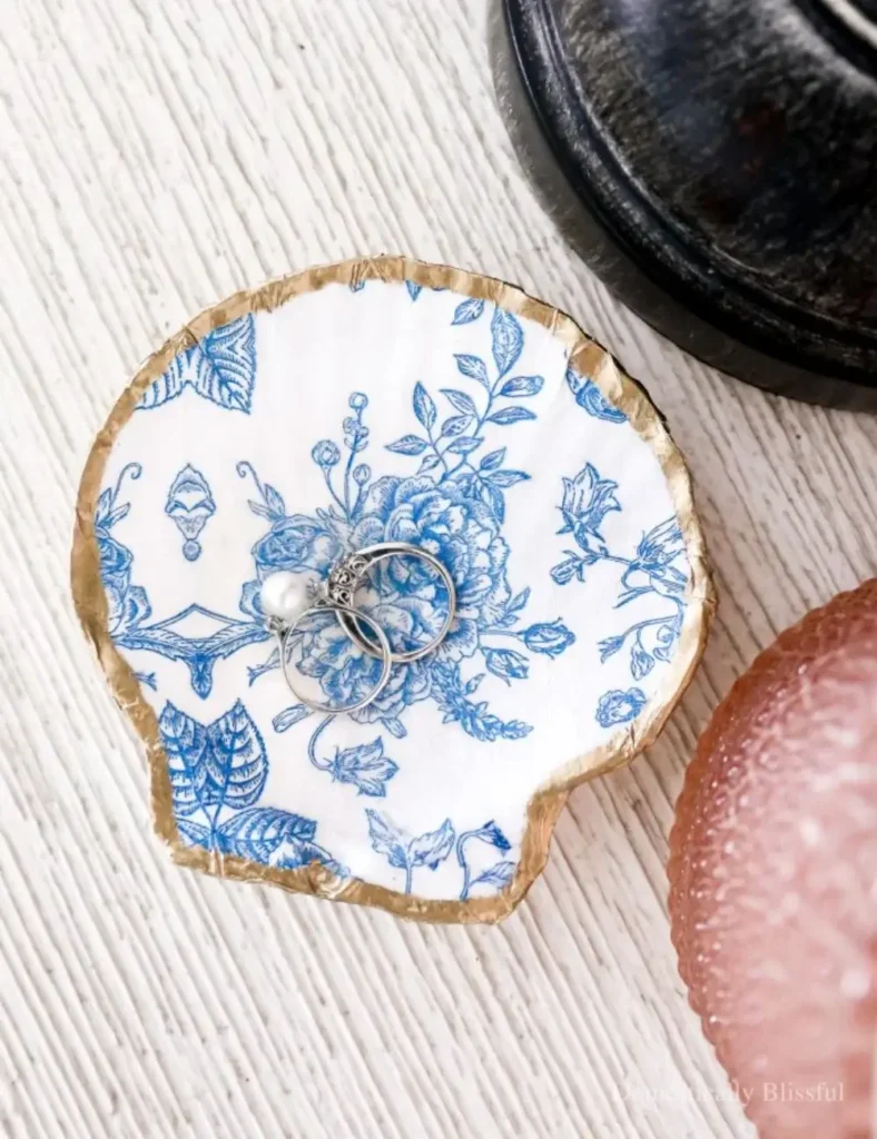 Large seashell decoupaged with a floral napkin design, used as a trinket dish